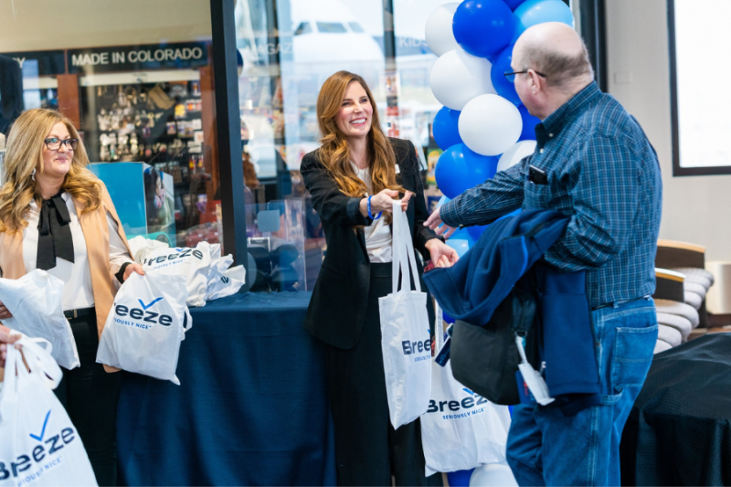 Mesa County Commissioner Bobbie Daniel helps give out Breeze Airways gift bags.