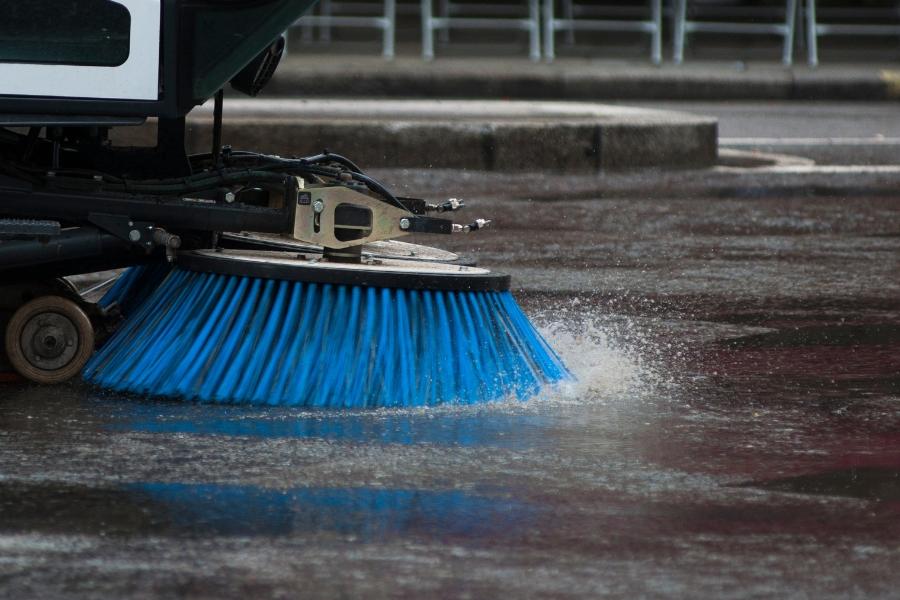 Blue street sweeper in action.