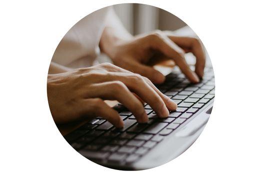 Close up image of two hands typing on a keyboard.