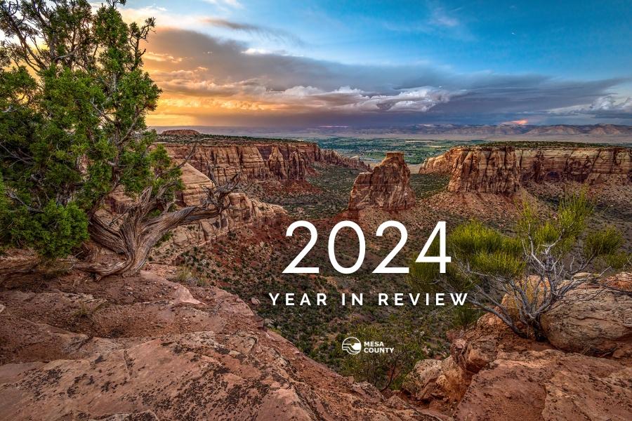 Colorado National Monument at sunset with white text reading, "2024 YEAR IN REVIEW" with the white Mesa County logo below. 