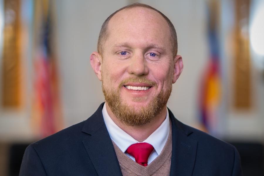 Man (Chair of Board of Mesa County Commissioners Cody Davis) smiling for headshot. 