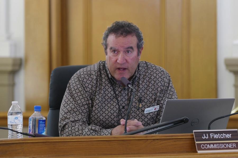 Man (Mesa County Commissioner JJ Fletcher) sits at a microphone speaking. 
