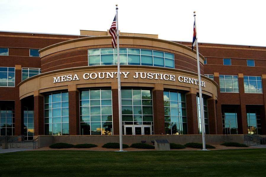 Brick Mesa County Justice Center building with an American and Colorado flag in the front. 