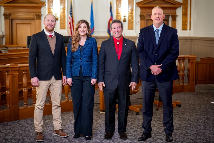 Four individuals (2025 Board of Mesa County Commissioners and County Administrator) in professional clothing smiling. 