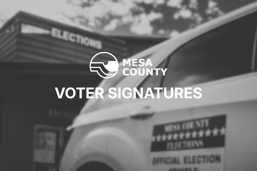 Black and white photo of a car in front of the Mesa County Elections office, with the county logo and the text "voter signatures" on top of it.